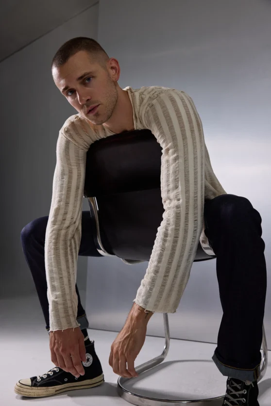Male fashion model showcasing a cable knit sweater for a modern editorial ecommerce brand shoot.