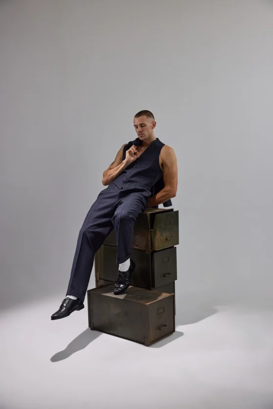 Artistic triple exposure of male model in white pants on black backdrop for fashion branding shoot.
