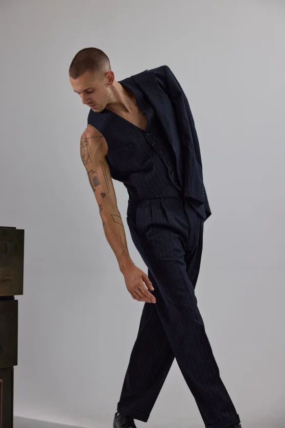 Fashion portrait of male model in denim jeans and a cable knit top in a modern ecommerce style.