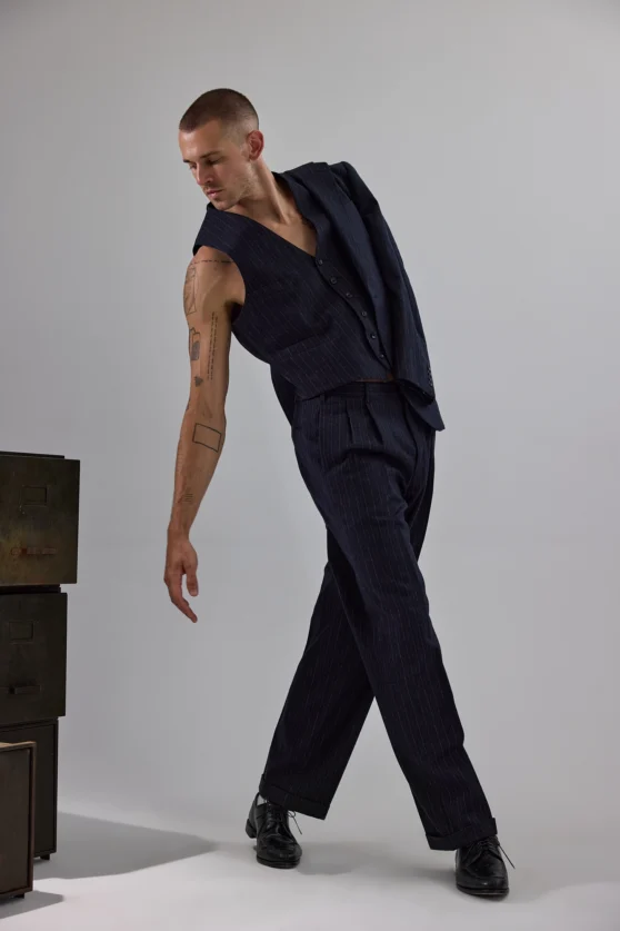 Editorial closeup of shirtless male model in white pants for commercial men’s fashion shoot.