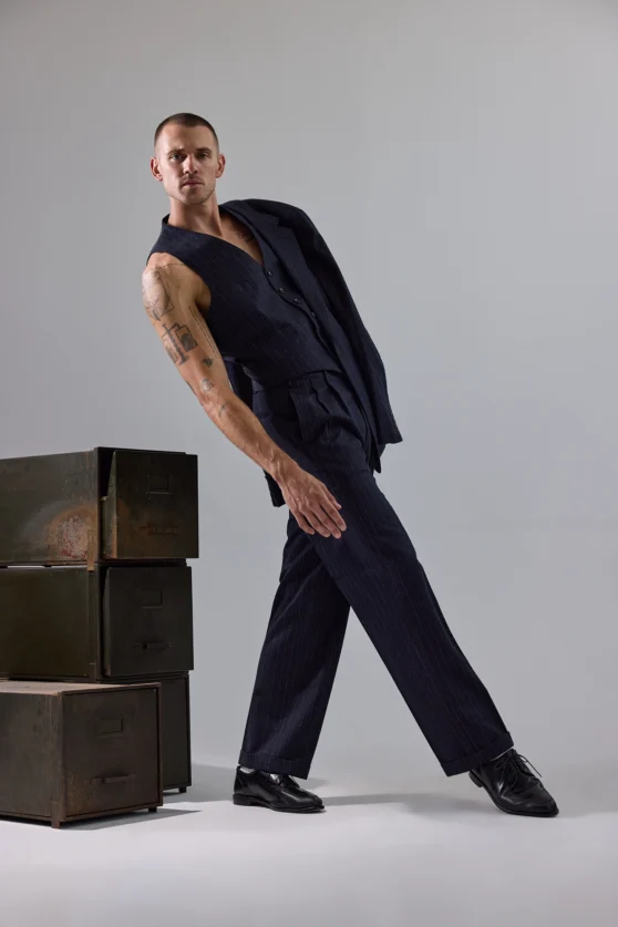 Studio fashion photography of male model in navy pants with minimal styling for online fashion retailers.