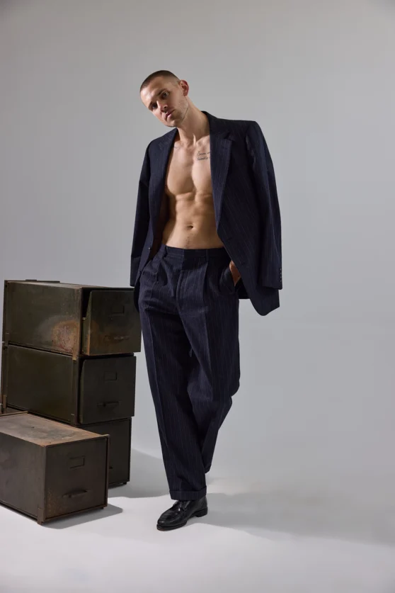 High fashion ecommerce photo of model twisting in navy suit for a lookbook.