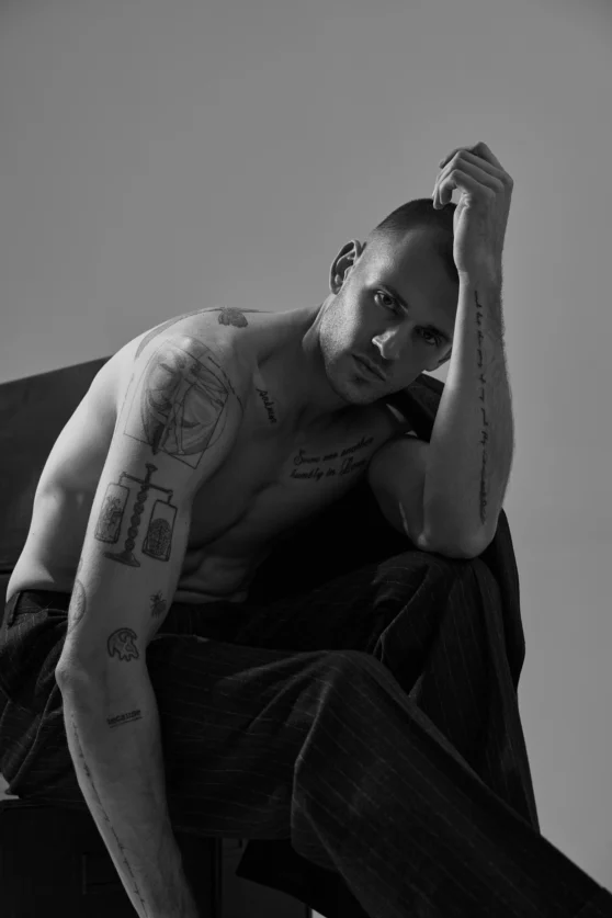 Stylish male model performing a twisting motion in a navy suit for editorial menswear campaign.