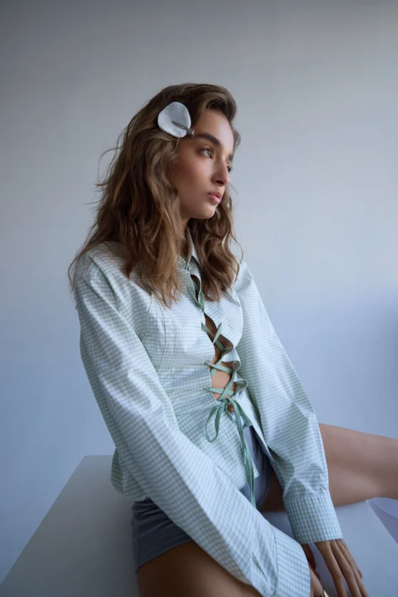 Minimal e-commerce photo of model in pastel outfit with side-part hairstyle