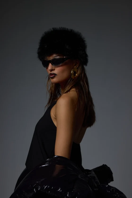 Fashion model with sunglasses in all-black outfit posing for creative editorial